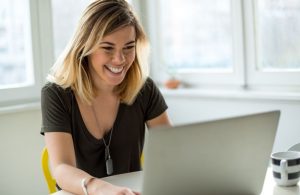 femme qui sourit devant son ordinateur